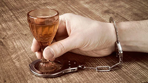 мужчина держит рюмку